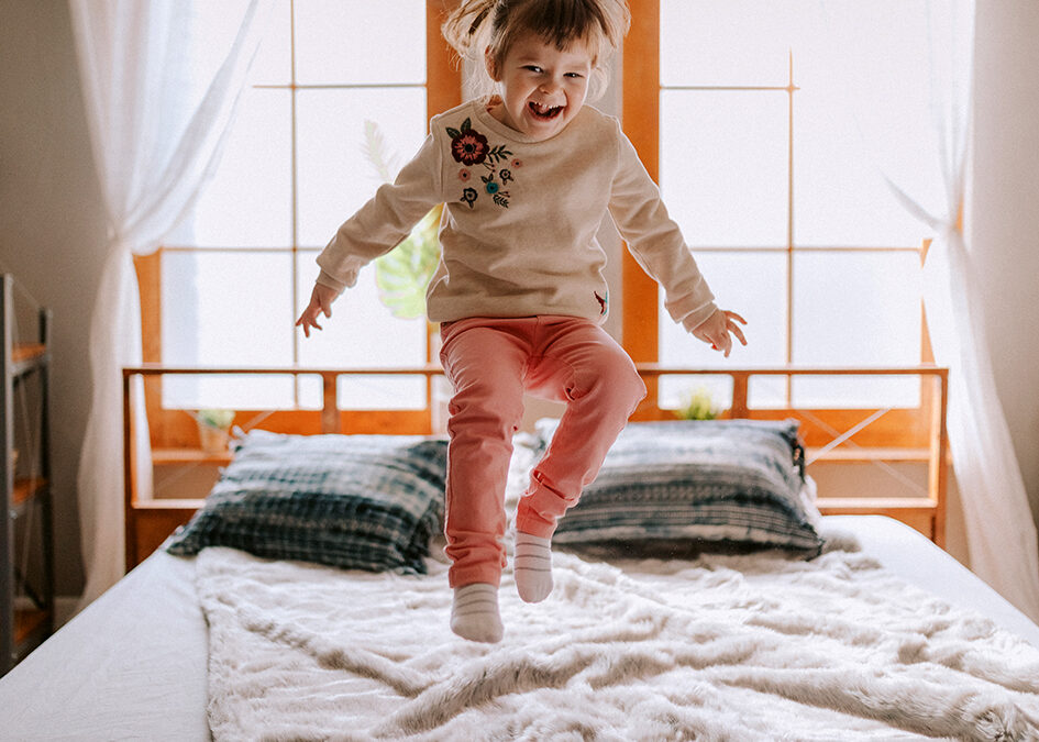 Child bouncing on bed