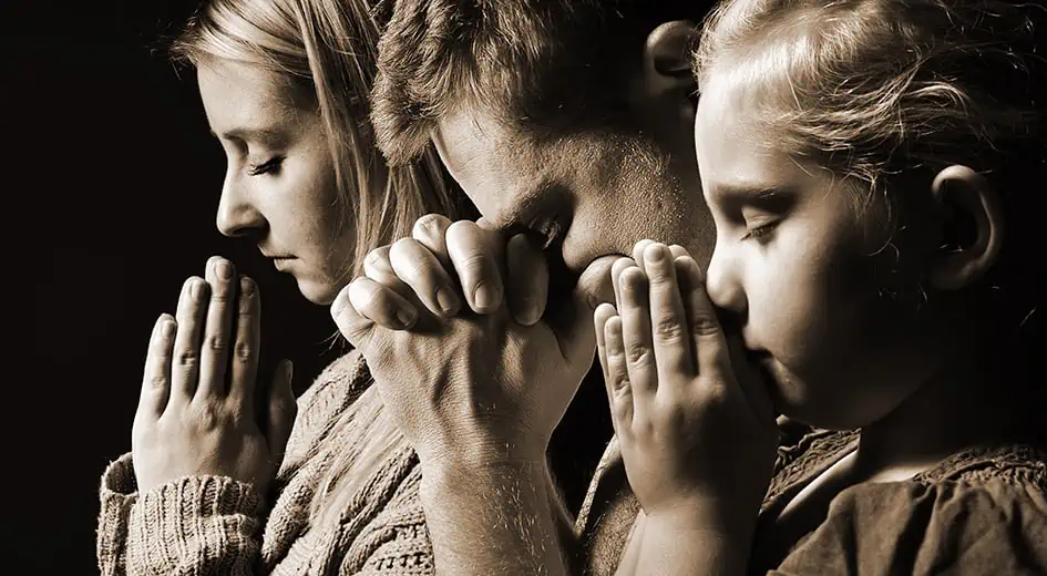Praying family. Man, woman and child.