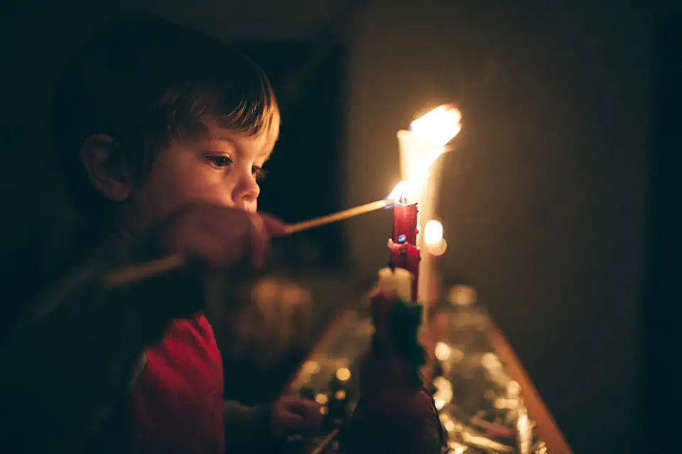 A child lites a candle